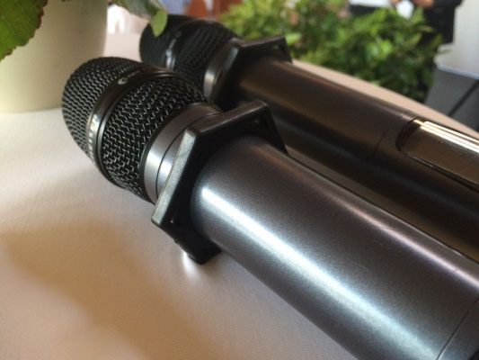 Zwei Funkmikrofone mit Rollschutzring microSTOP Star liegen sicher auf dem Tisch